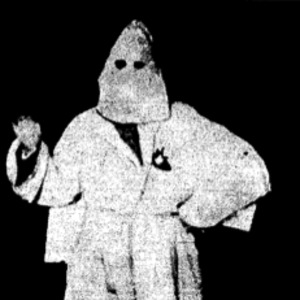 Picture of a Klansman accompanying an article titled, "Nazi Swastika Burns Like Fiery Cross."