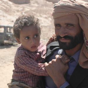 Yemeni man holding a young child